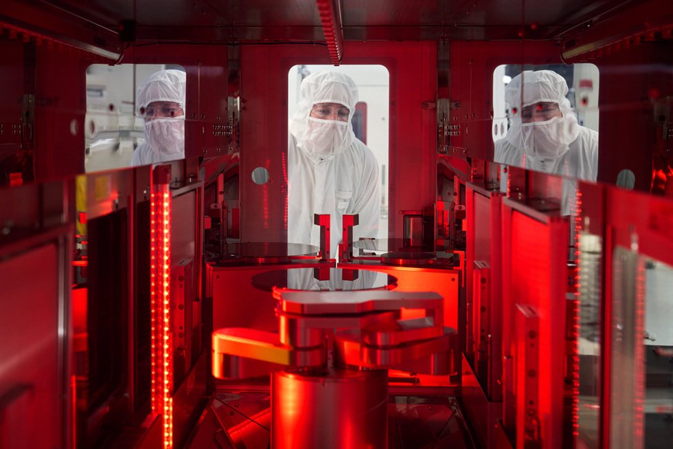 Tres trabajadores con ropa protectora en la planta de fabricación de obleas semiconductoras de Texas Instruments en Lehi, Utah.