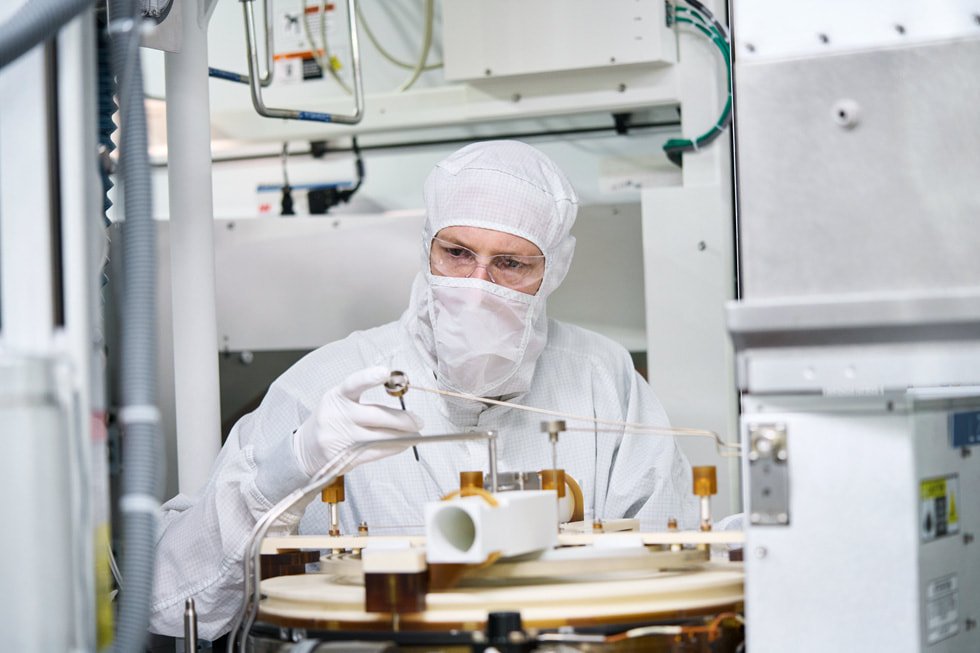 Un trabajador con ropa protectora examina la maquinaria en la planta de fabricación de obleas de semiconductores de Texas Instruments en Lehi, Utah.